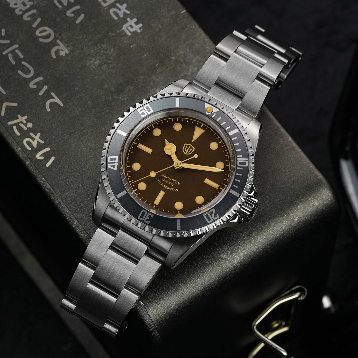 Watchdives WD5514Q 40mm quartz dive watch, tropical brown dial with yellow indices, watch displayed on textured surface, 316L stainless steel bracelet.